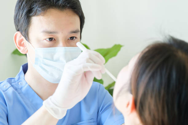 病院でのアジアの医師の健康診断 - dentist office ストックフォトと画像