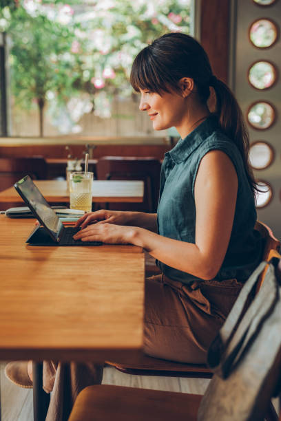 istock Young Freelance Businesswoman Working on her Tablet Computer at a Cafe 1246728974