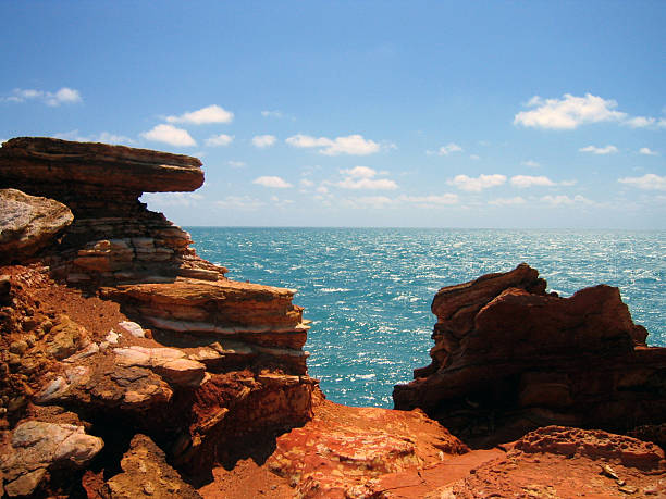 Great Ocean Road Australia with orange rock formations and stunning deep blue water and waves crashing