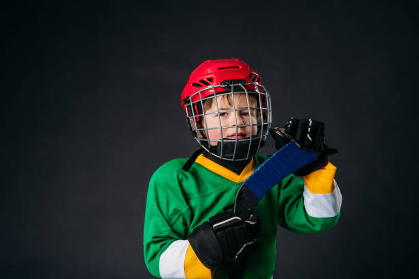 istock A happy five year old boy is posing in studio with his hockey equipment. 1246751520