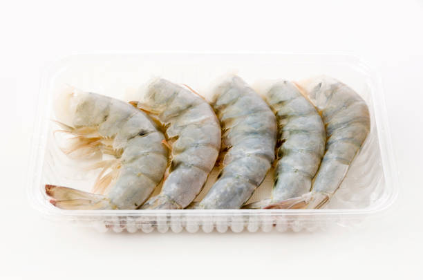 istock Fresh black tiger shrimp tails in plastic pack on white background 1246825890