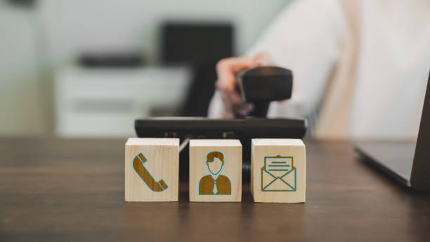 istock VOIP headset and Icon communication on the wood block. concept call center support. 1246867183