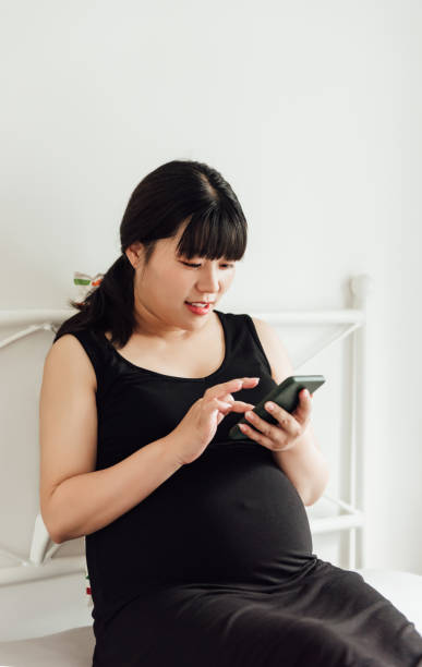 istock A young Asian pregnant woman is using an electronic device 1246867471