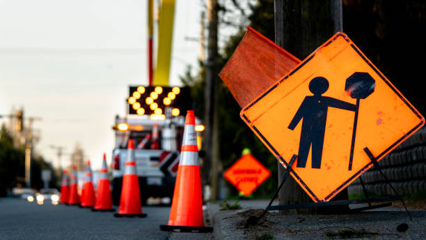 Lane closure on a busy road due to maintenance signs detour traffic temporary street work orange lighted arrow, barrels, and cones. Lane closure on a busy road due to maintenance signs detour traffic temporary street work orange lighted arrow, barrels, and cones. temporary stock pictures, royalty-free photos & images