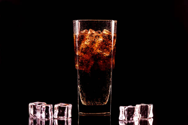 istock Cola glass with ice cubes and droplets, isolated on black background 1246905792
