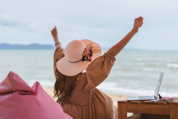 istock Asian woman open arm relax at the beach 1246905841
