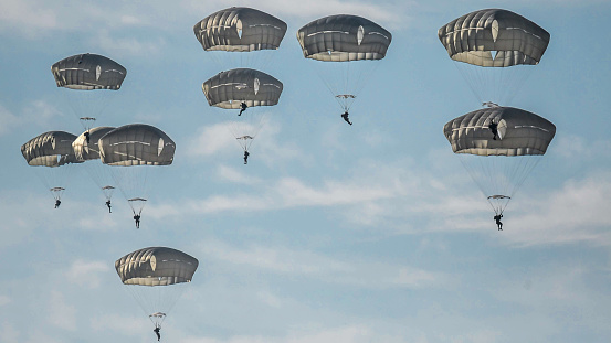 Paratroopers jumping out of a US Air Force Lockheed Martin C-130 Hercules transport plane from Ramstein Air Base. The Netherlands - September 21, 2019