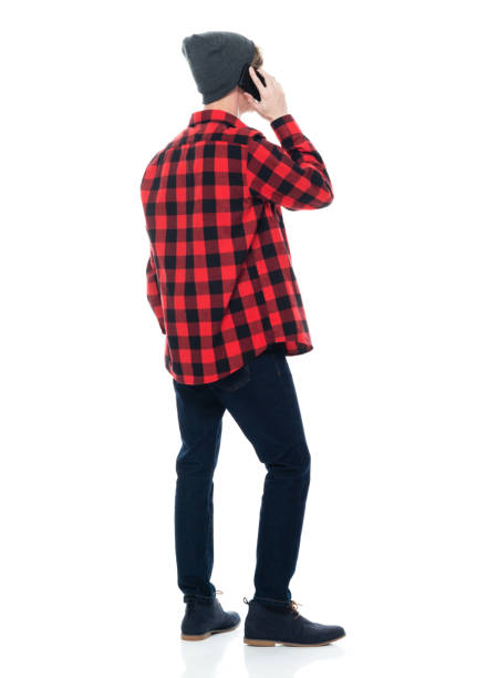 istock Caucasian young male hipster standing in front of white background wearing boot and using smart phone 1246910071