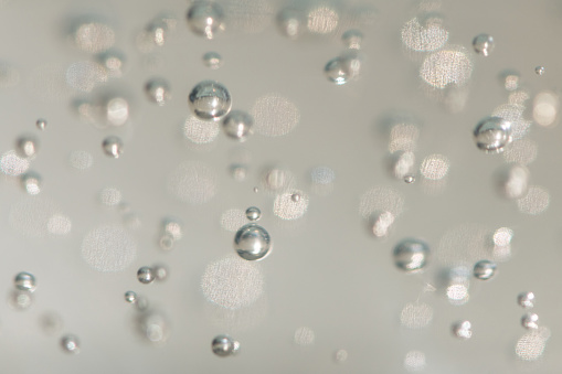 A selective focus shot a abstract background of glowing and iridescent bubbles. Blurred background