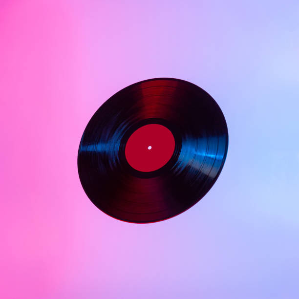 istock Black LP vinyl disc lit with colorful light on abstract light background with room for text 1246912209
