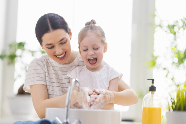 girl and her mother are washing hands - washing hand imagens e fotografias de stock