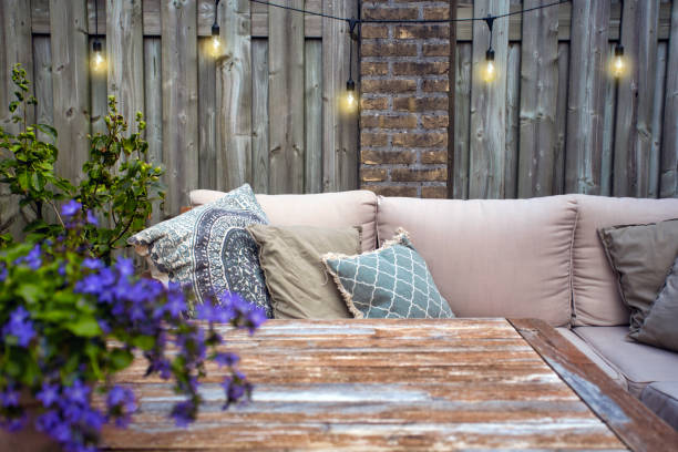 meubles de jardin extérieurs élégants, sofa avec coussins et lampes, ampoules suspendues, coin moderne confortable sur la terrasse - home decorating decor furniture table photos et images de collection