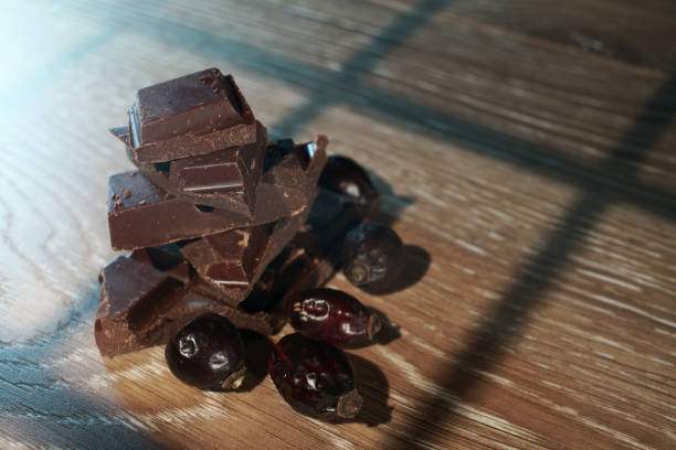 istock Chocolate pieces on a wooden table with an unusual light pattern. Macro. 1246918346