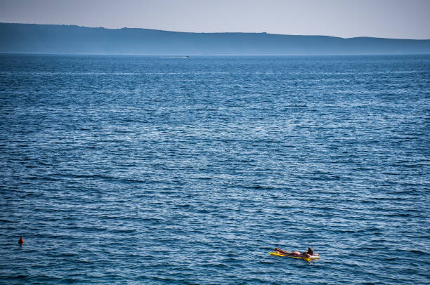 istock Blonde girl on blue sea 1246918686