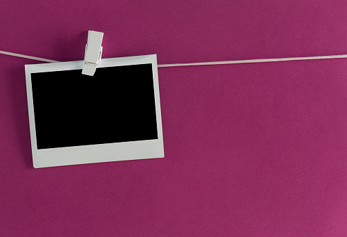Photo frame on a clothesline, purple background.