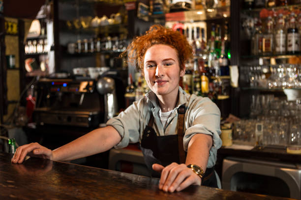 istock Smiling Female Bartender at bar counter 1246928256
