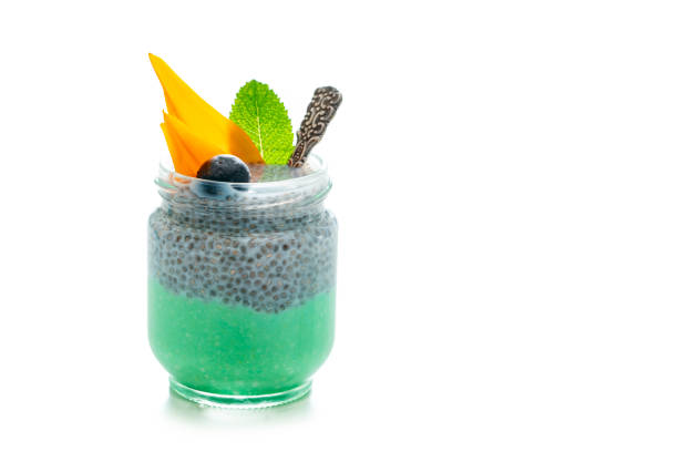 récipient en verre sain de yogourt de petit déjeuner avec la feuille verte de menthe de mûre de spiruline et des fleurs - milk shake smoothie blackberry isolated photos et images de collection