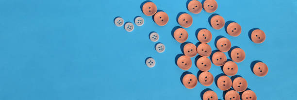 istock On a blue background a scattering of coral buttons. Needlework. Accessories for sewing. Copy space. Banner. 1246939541
