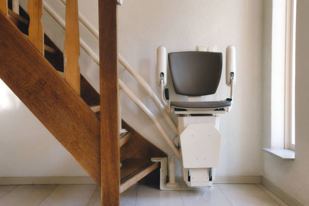 Automatic stairlift on staircase for elderly or disability in a house, Automatic stairlift on staircase for elderly or disability in a house, taking people up and down exercise room photos stock pictures, royalty-free photos & images