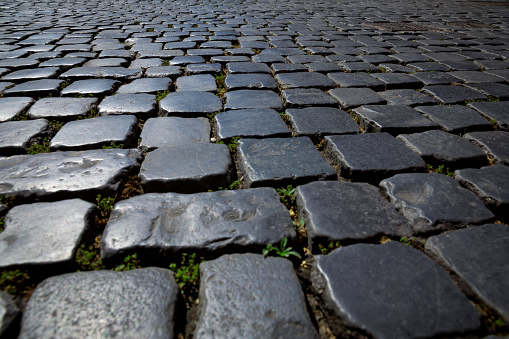 The road is paved with granite stones of a square shape as a background or a backdrop