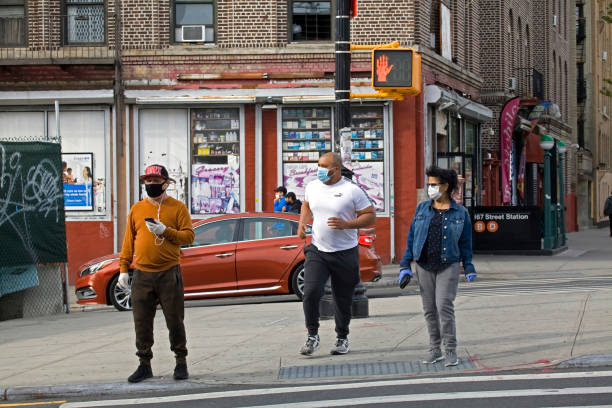Latino people crossing street wearing masks during COVID-19 pandemic Bronx NY stock photo