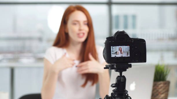 istock Young beautiful blogger girl working in office while shooting on camera 1246955233
