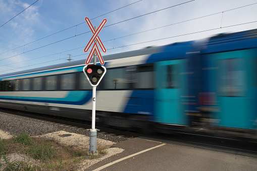 a modern intercity train go through a railway crossing