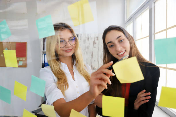 istock Two businesswomen looking at sticky notes 1246961647
