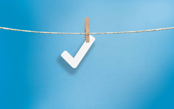 Cut out OK Sign Check Mark icon in white cut out paper on blue background. High resolution image with copy space.