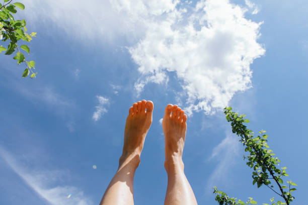 Female feet up infront of the cloudy sky