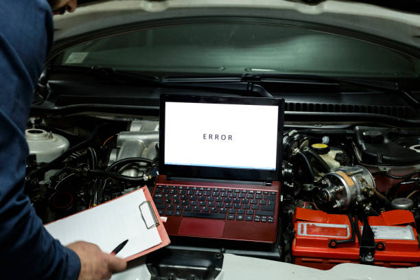 istock Mechanic examining car engine with help of laptop 1246974327