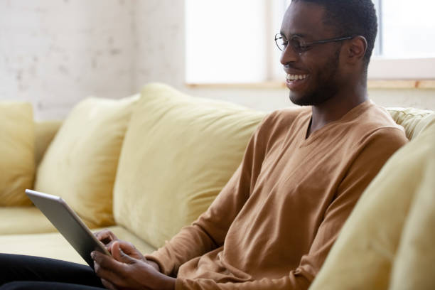 istock African guy holding digital tablet laugh enjoy funny videos 1246980203