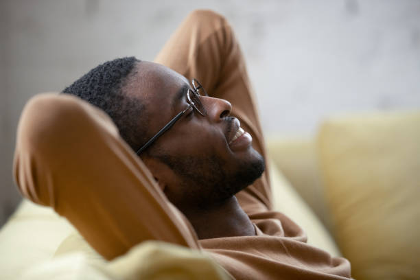 istock Closeup peaceful young african ethnicity man resting leaned on couch 1246980226