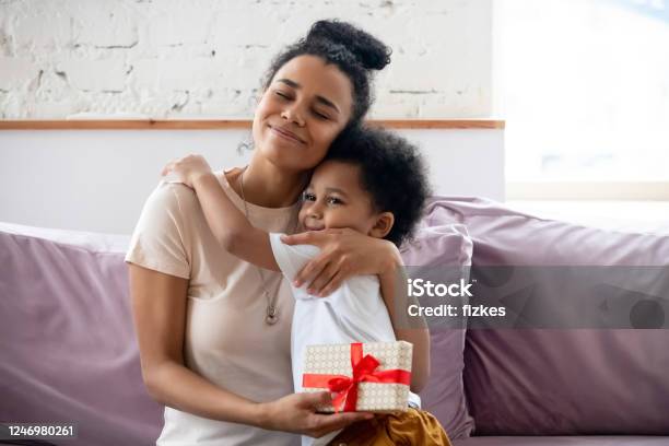 African Son Makes Surprise To Mom On Mothers Day Stock Photo - Download Image Now - Gift, Mother, Embracing