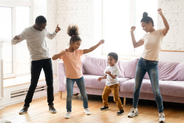 afrikanische familie mit kindern tanzen im modernen wohnzimmer - living room people joy happiness stock-fotos und bilder