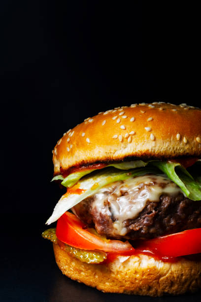 istock burger with chop, steak, cheese, salad on a black background 1246982624