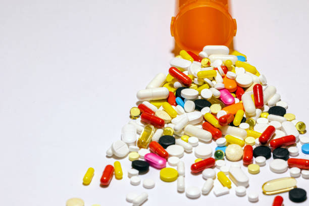 горсть таблеток в треугольной форме. - store herbal medicine drug abuse capsule стоко�вые фото и изображения
