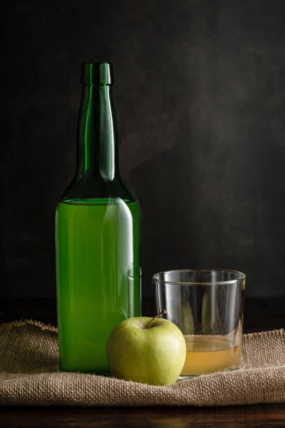 bottle of asturian cider with glass and apple on dark background. - asturiana imagens e fotografias de stock