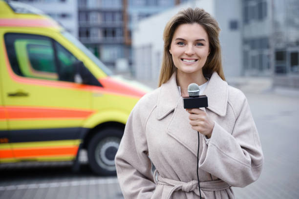 Smiling news reporter speaking into a microphone