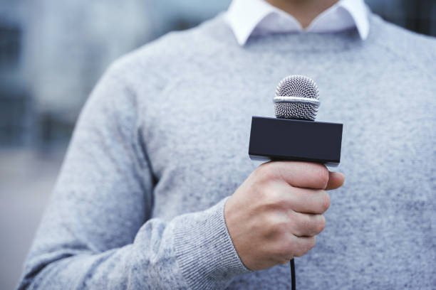 istock Male hand with a reporter microphone 1246987984