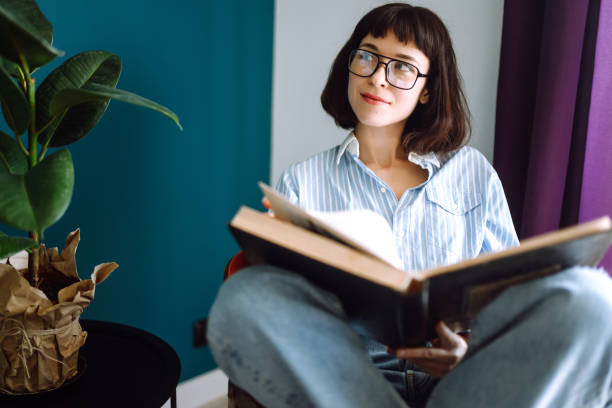 istock A young woman reads a book at home 1247002079
