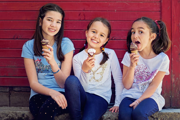 Portrait of girlfriends eating ice cream and having fun together Portrait of girlfriends eating ice cream and having fun together stealing ice cream stock pictures, royalty-free photos & images