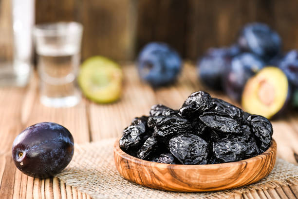 ciruelas frescas y secas en un tazón de oliva sobre mesa. - slivovitz fotografías e imágenes de stock