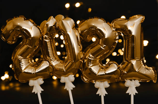 istock Shiny balloons symbols 2021 on festive background. 1247010992