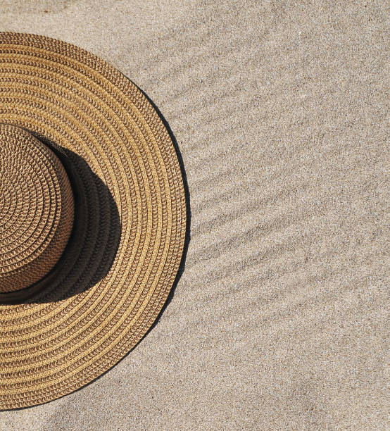 istock Hat and sun cream protection on sand. Summer time concept. 1247013038