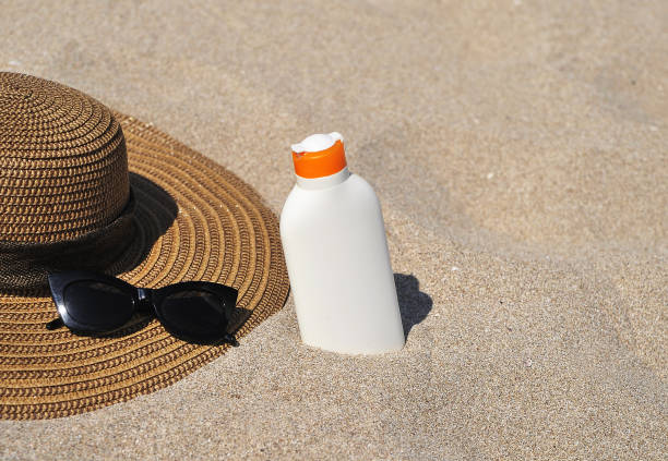 istock Hat and sun cream protection on sand. Summer time concept. 1247013571