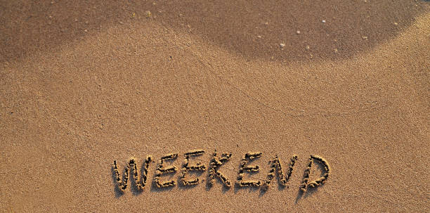istock The word weekend written on sand background. 1247014304