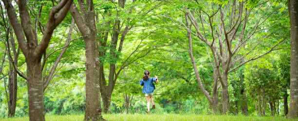 Two carefree women walking and hugging each other during a hike. Carefree friends on holiday hugging during a hike. Two friends walking down a road in a forest during a hike hugging