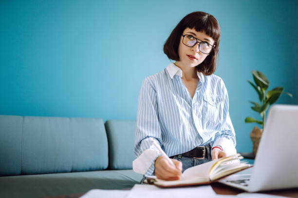 istock Beautiful woman at home writing and working with diary. 1247025485