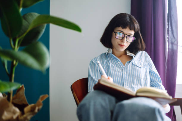 istock Beautiful woman at home writing and working with diary. 1247025986
